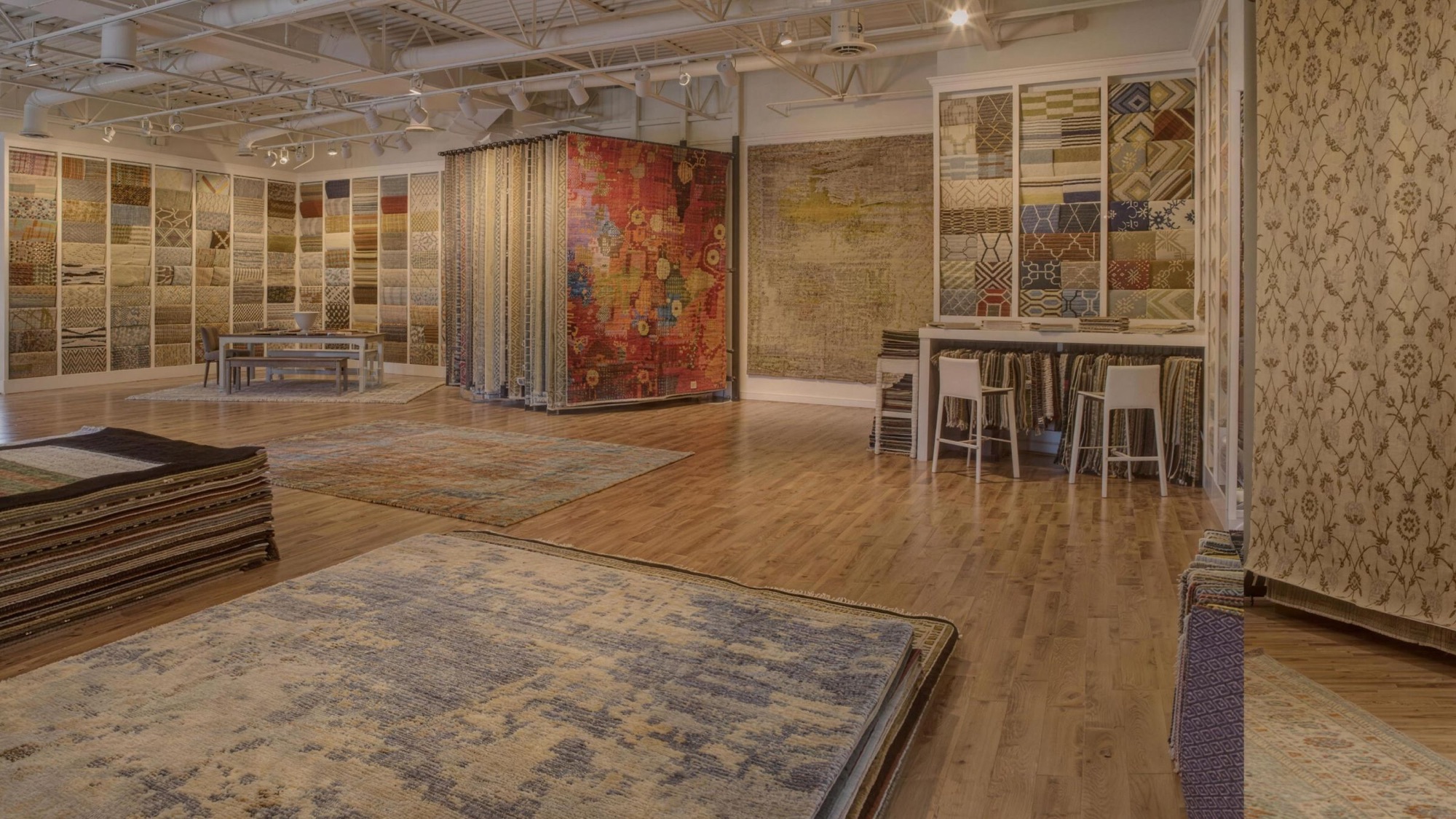 The Senneh Knot showroom floor, with rugs laid out and hanging on the walls
