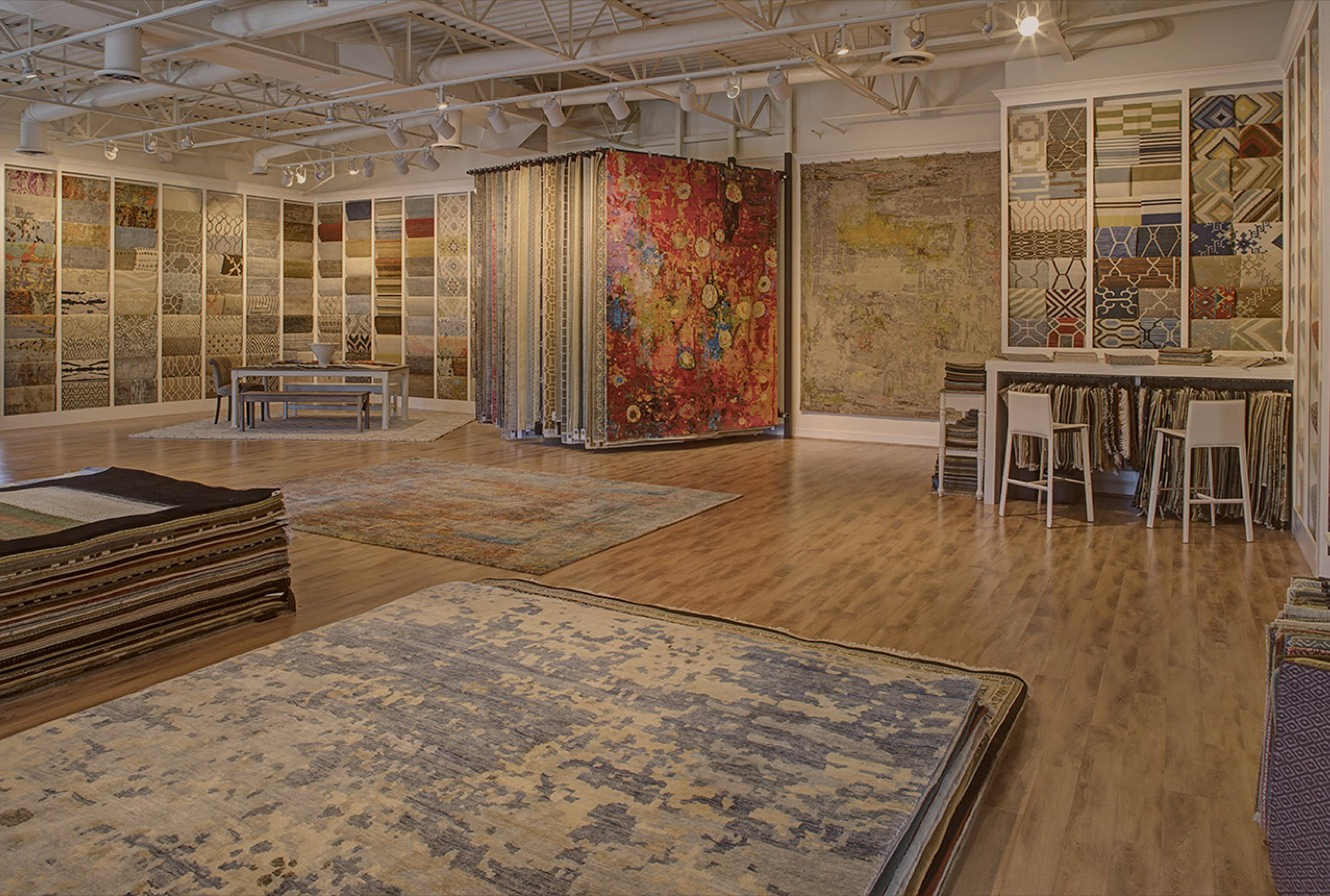 The award-winning Senneh Knot showroom floor, with rugs laid out and walls of rug samples