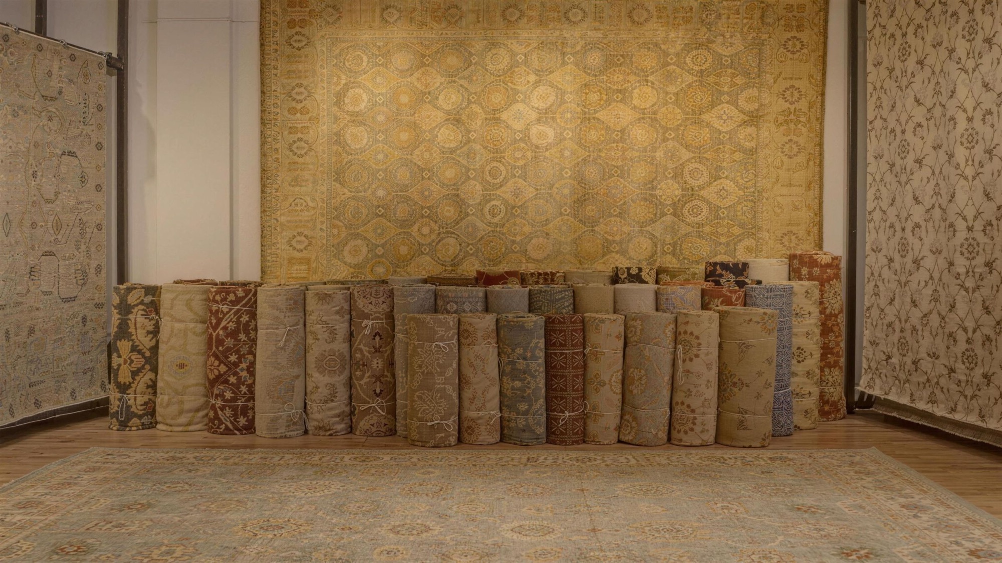 Rolled hand-knotted rugs stacked in the Senneh Knot showroom